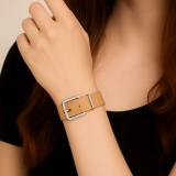 Das naturelle Armband ist mit einer silberfarbenen Metallschnalle (Rollschnalle) und passender Schlaufe ausgestattet