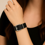 Das schwarze Armband ist mit einer silberfarbenen Metallschnalle (Rollschnalle) und passender Schlaufe ausgestattet